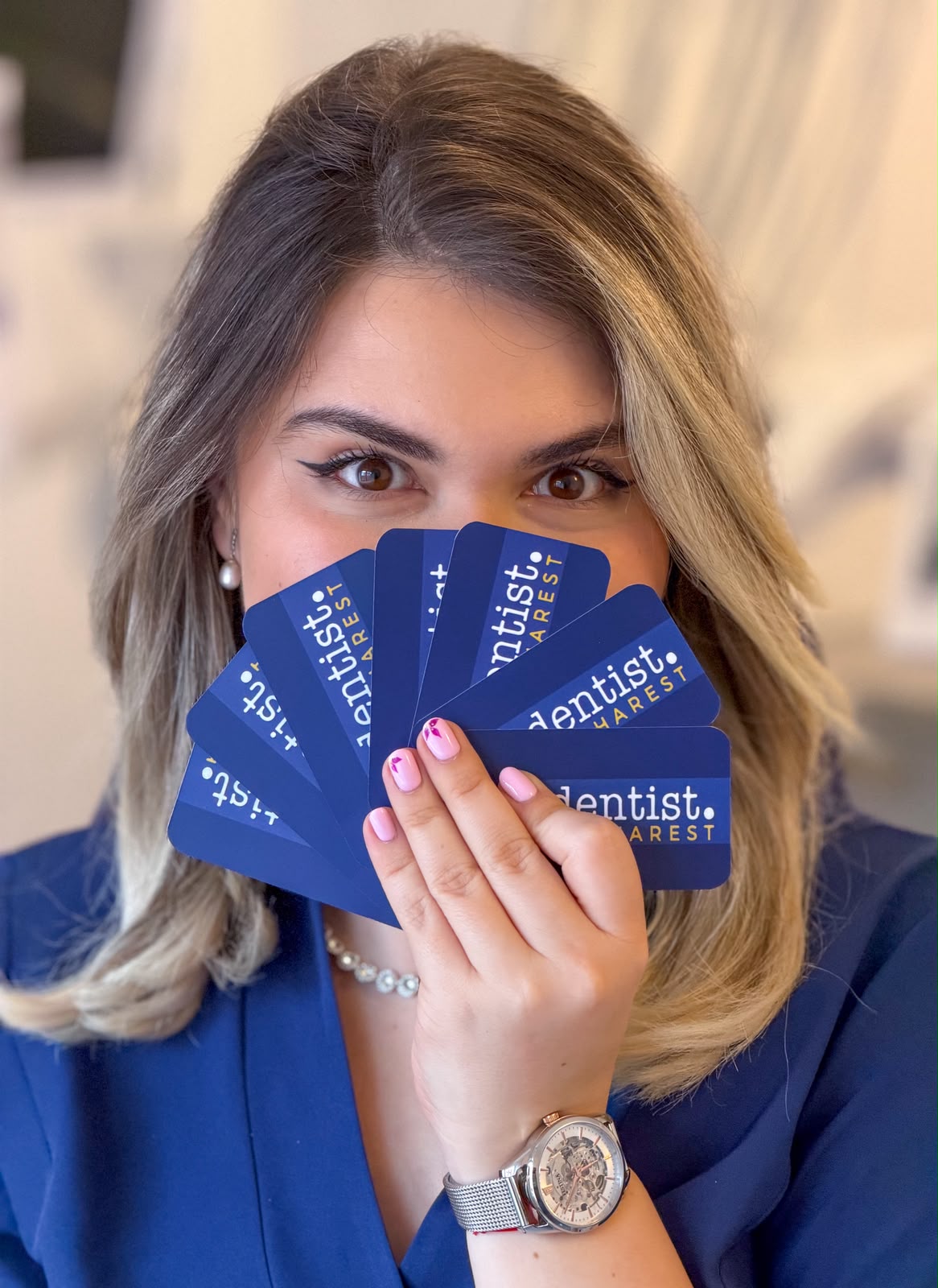 Medic din echipa The Dentist Bucharest cu cărțile de vizită ale clinicii