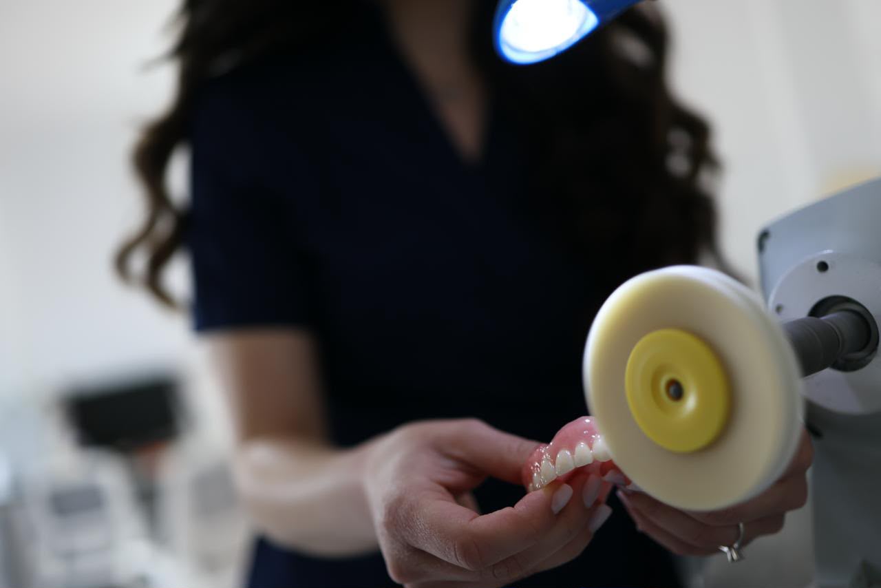 Finisarea unei lucrări protetice pe roata de lustruit, în laboratorul dentar